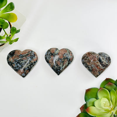 3 rhyolite hearts with decorations surrounding them