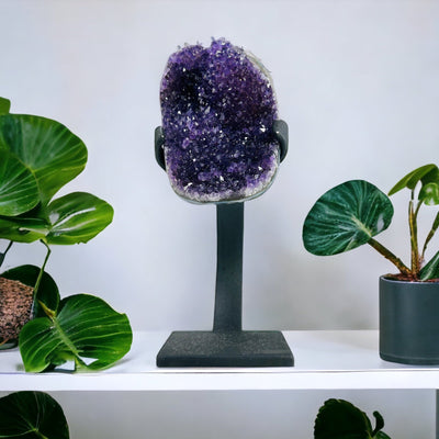 purple amethyst on metal stand with decorations in the background