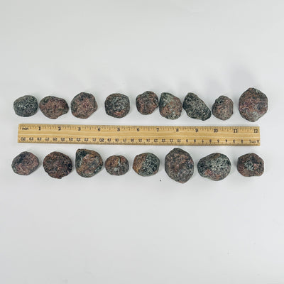 rough garnet pieces next to a ruler for size reference