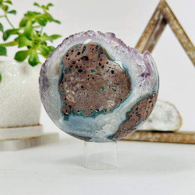 amethyst druzy sphere with decorations in the background