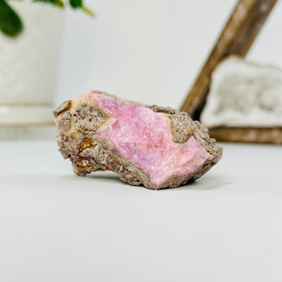 pink cobalto calcite cluster with decorations in the background