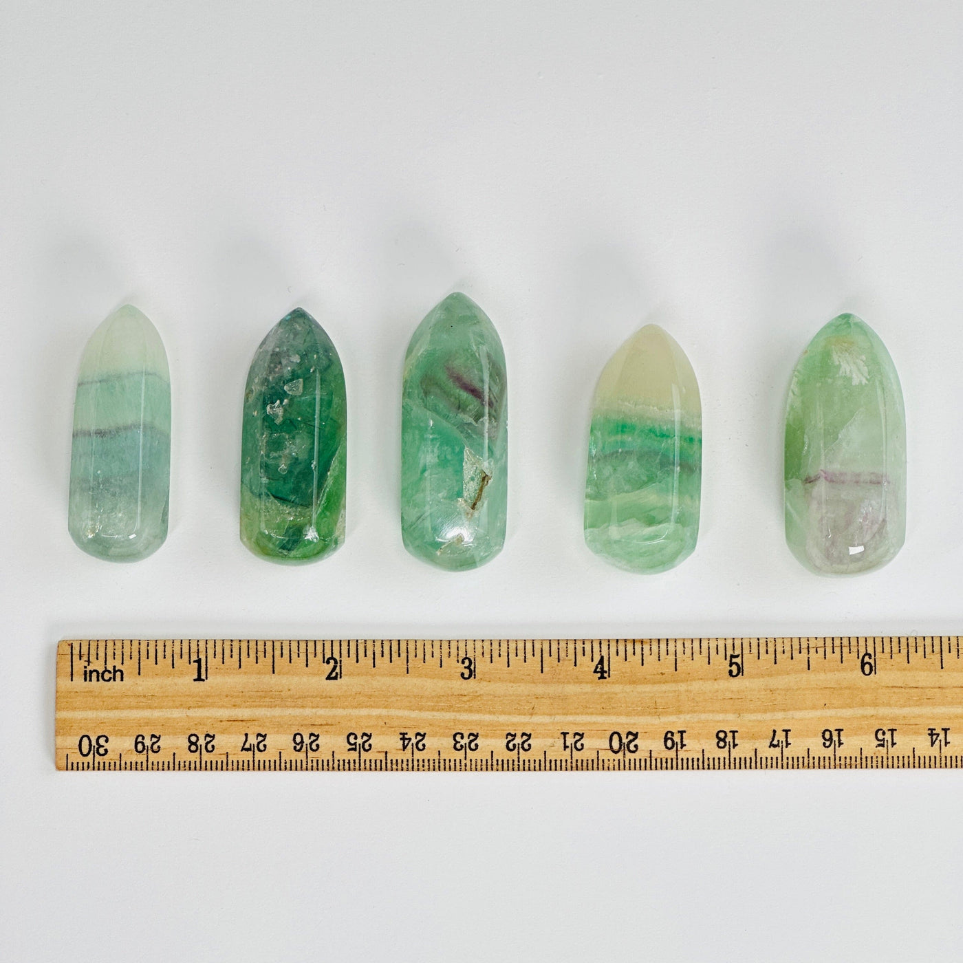 5 fluorite massage points next to a ruler for size reference