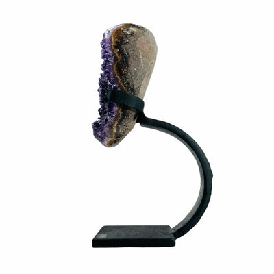 semi polished amethyst on stand on white background