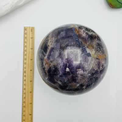 chevron amethyst sphere next to a ruler for size reference
