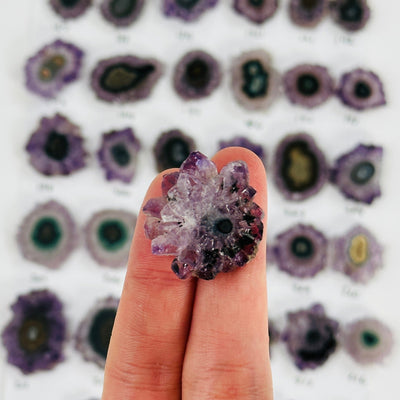 amethyst stalactite slice on fingers for size reference