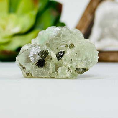 green fluorite with epidote growth with decorations in the background