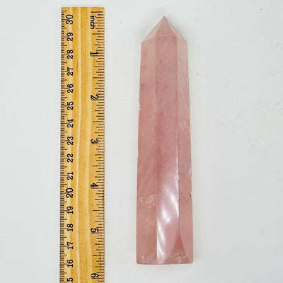 rose quartz polished point next to a ruler for size reference