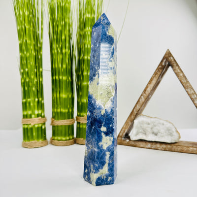 sodalite polished point with decorations in the background
