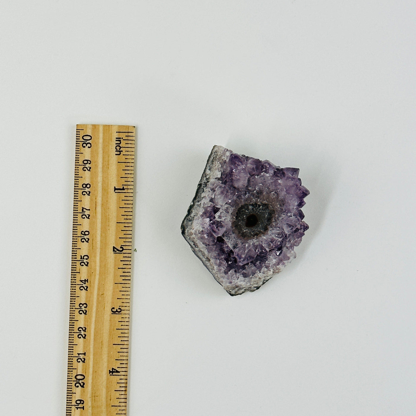 amethyst stalactite cluster next to a ruler for size reference