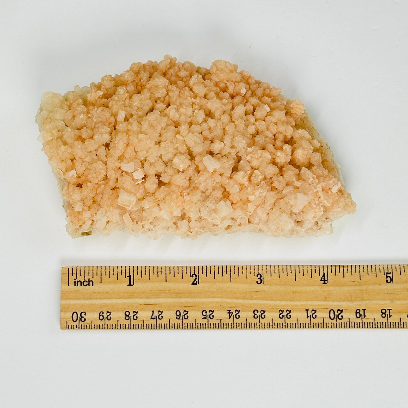 pink halite formation next to a ruler for size reference