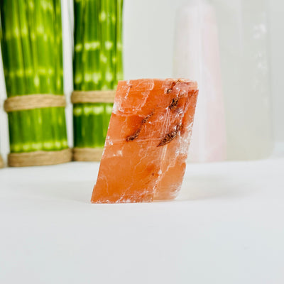 side view of pink optical calcite with decorations in the background