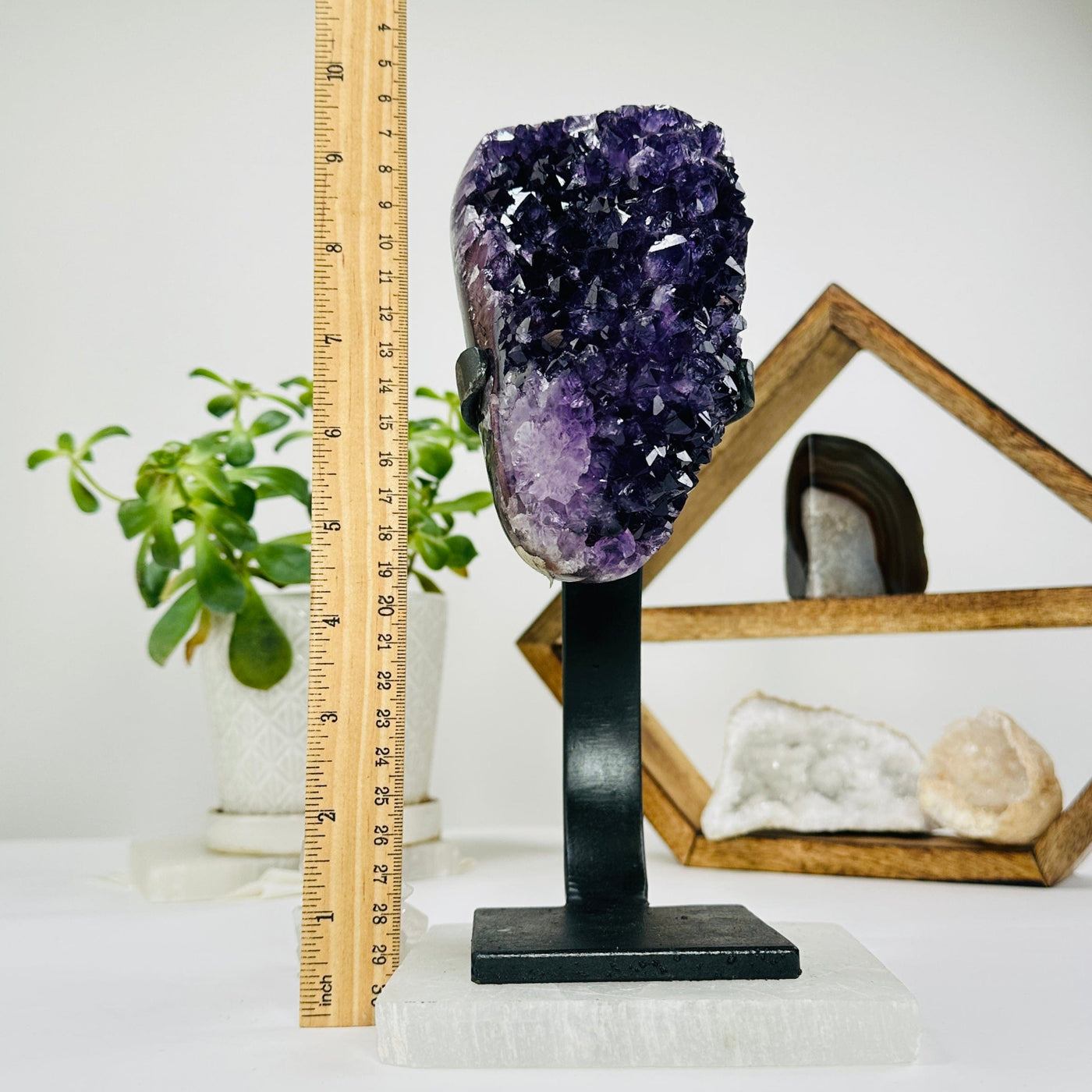 amethyst on metal stand next to a ruler for size reference