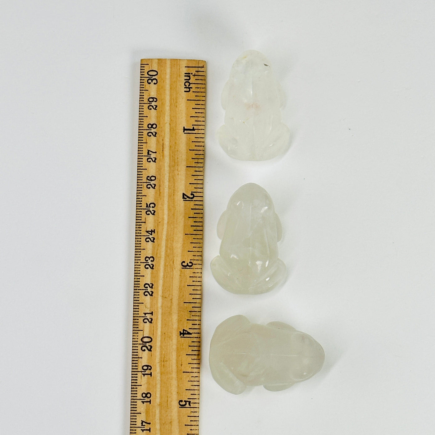 3 crystal quartz frogs next to a ruler for size reference