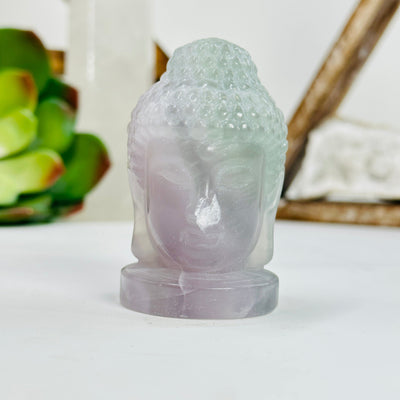 fluorite buddha head with decorations in the background