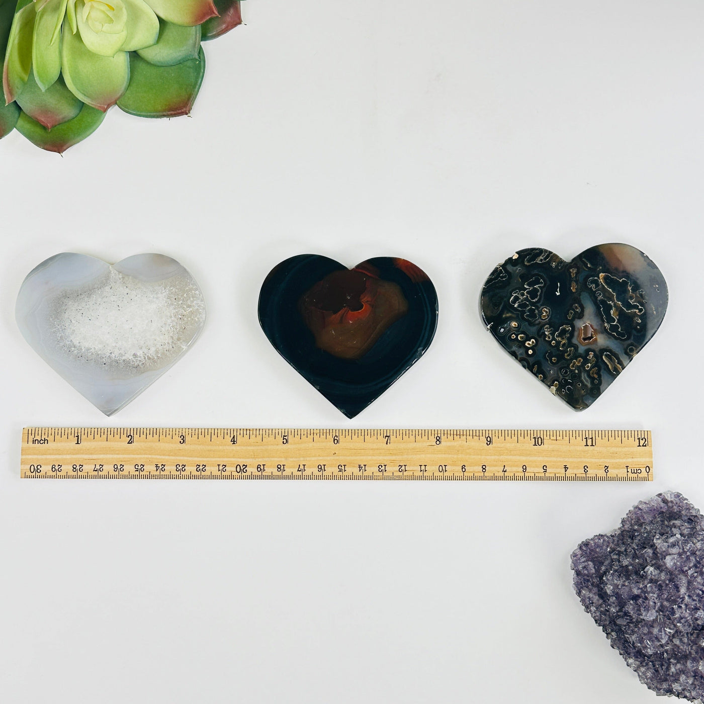 all variants of Natural Agate Heart Slices next to a ruler for size reference