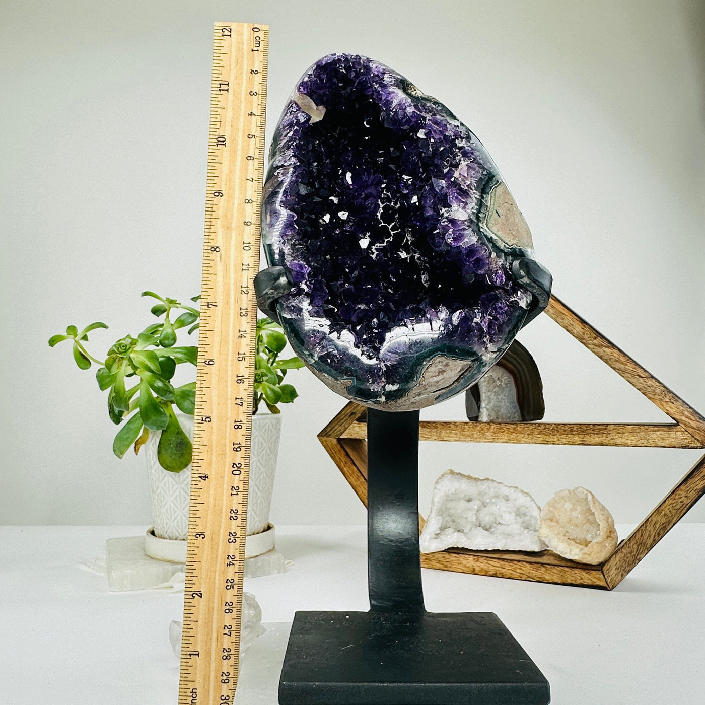 amethyst on metal stand next to a ruler for size reference