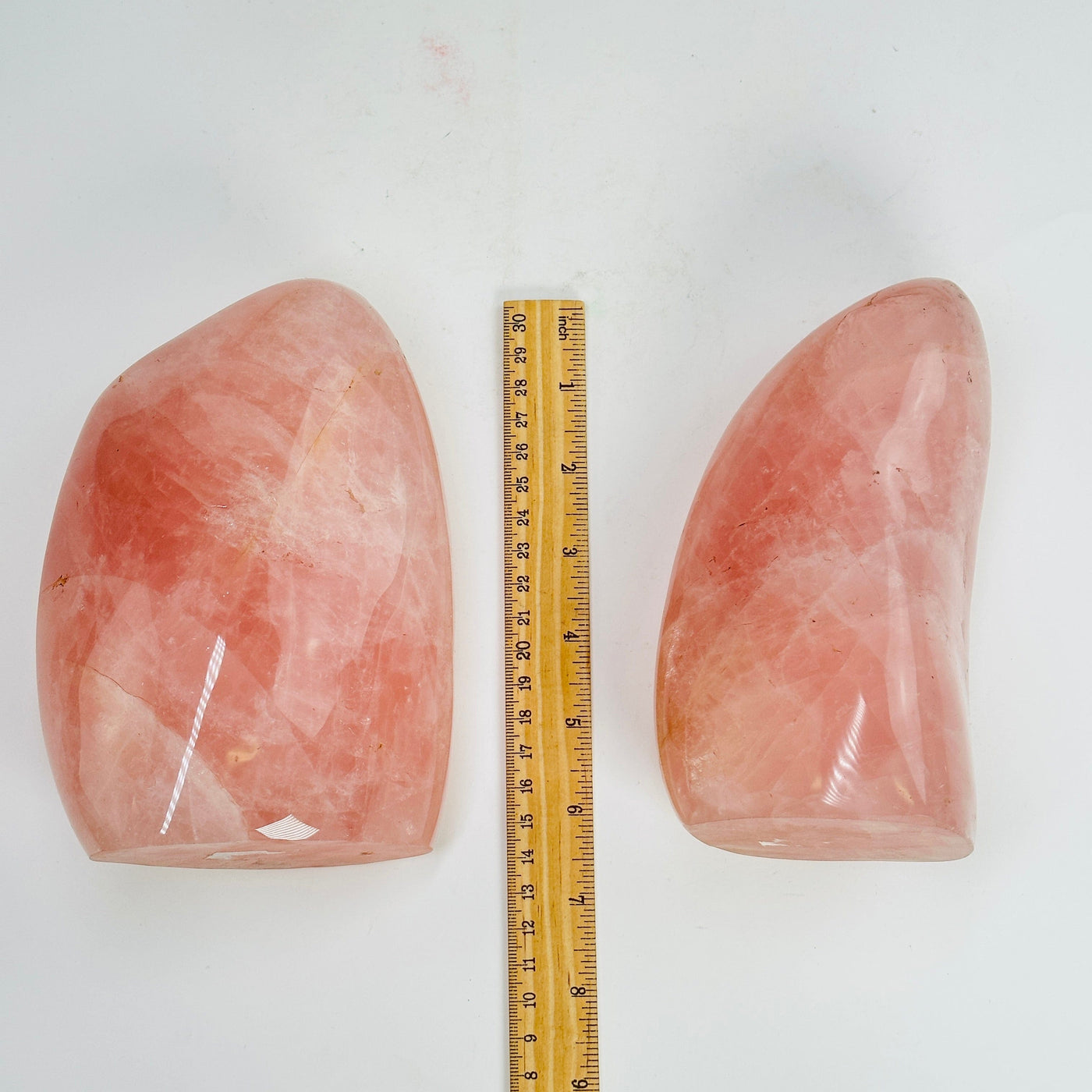 rose quartz polished cutbases next to a ruler for size reference