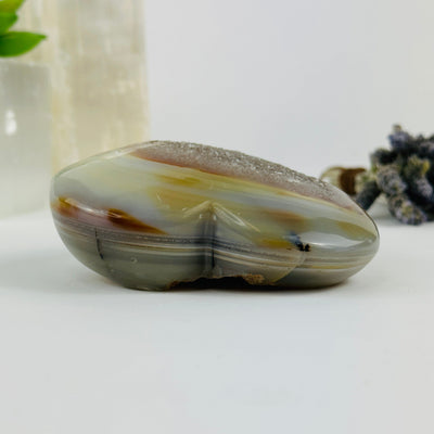 Side view of agate heart with decorations in the background