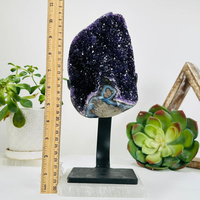 amethyst on stand next to a ruler for size reference