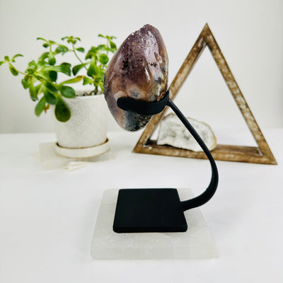 amethyst on metal stand with decorations in the background