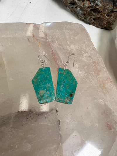 pair of turquoise earrings on crystal background
