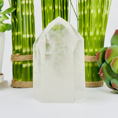 crystal quartz polished point with decorations in the background