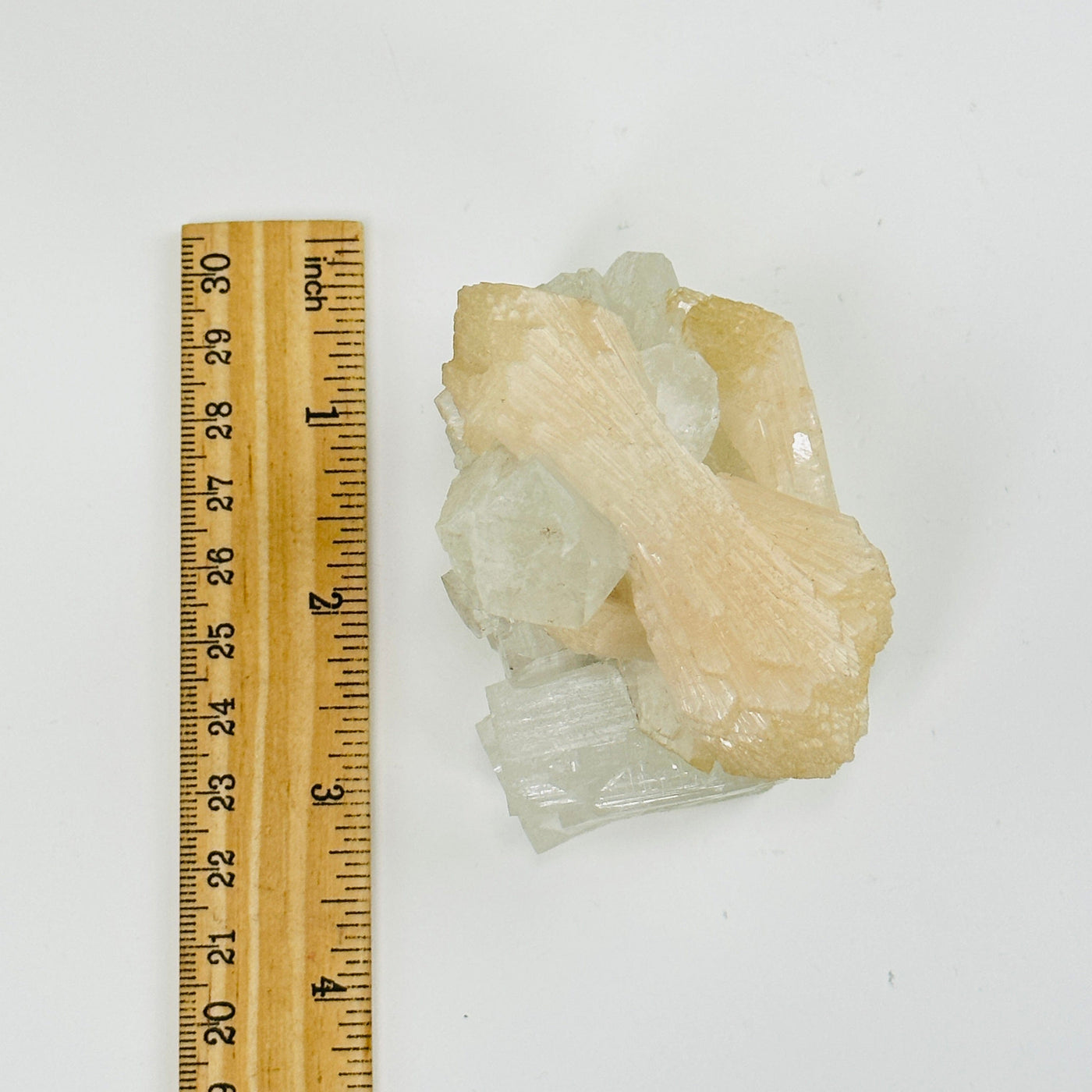apophyllite with calcite formation next to a ruler for size reference