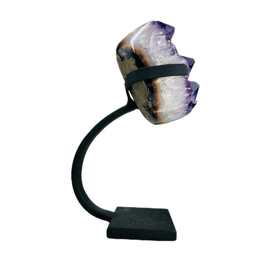 side view of polished amethyst on stand on white background