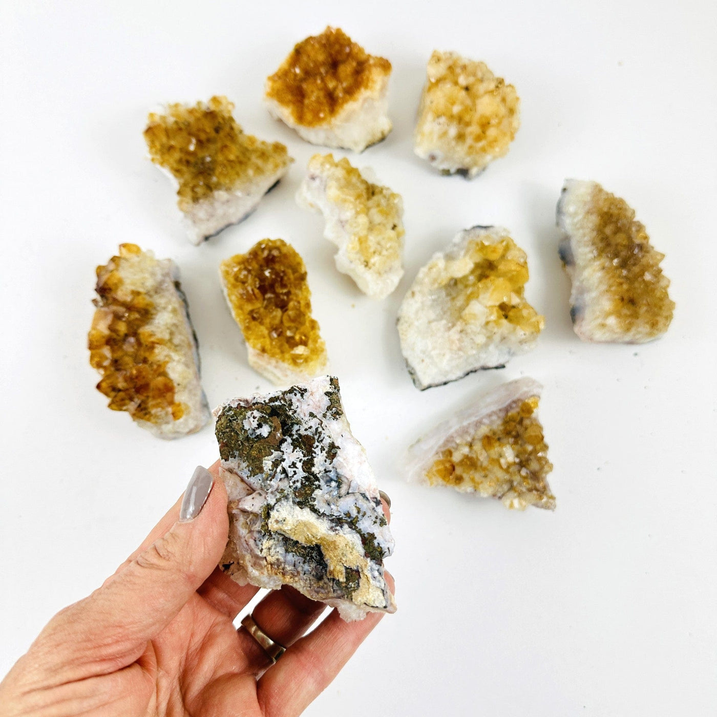 Citrine Crystal Clusters  with one in a hand showing back of cluster