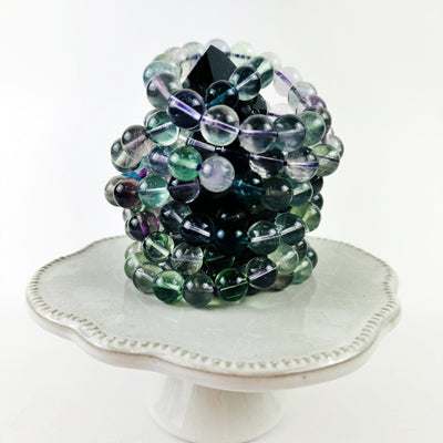 Rainbow Fluorite Round Bead Bracelets stacked on a table