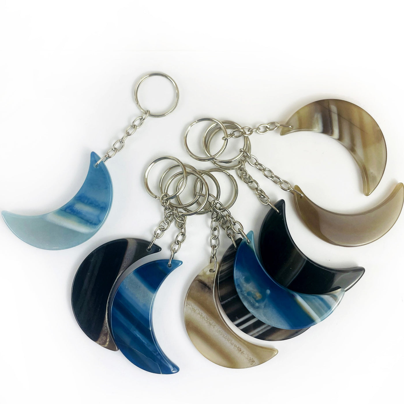 Crescent Moon Agate Key Chains in black, blue and natural agate showing the variation of agate patterns from this stock
