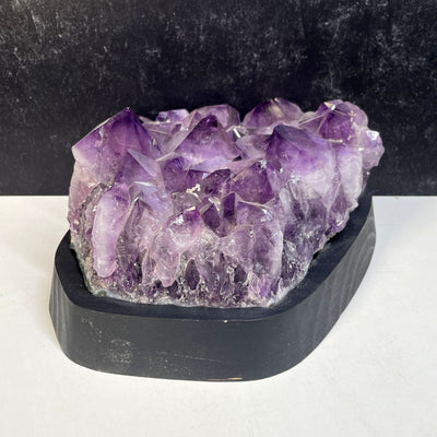 Amethyst Crystal Cluster on Wooden Base from a side view