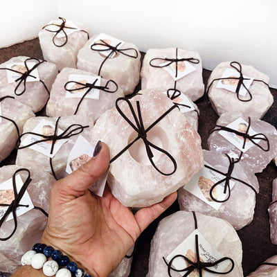 20 rose quartz candles with one in a hand for size reference
