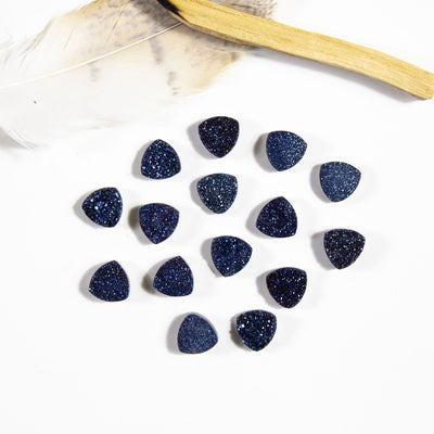 multiple mystic blue triangle druzy cabochons displayed on white background