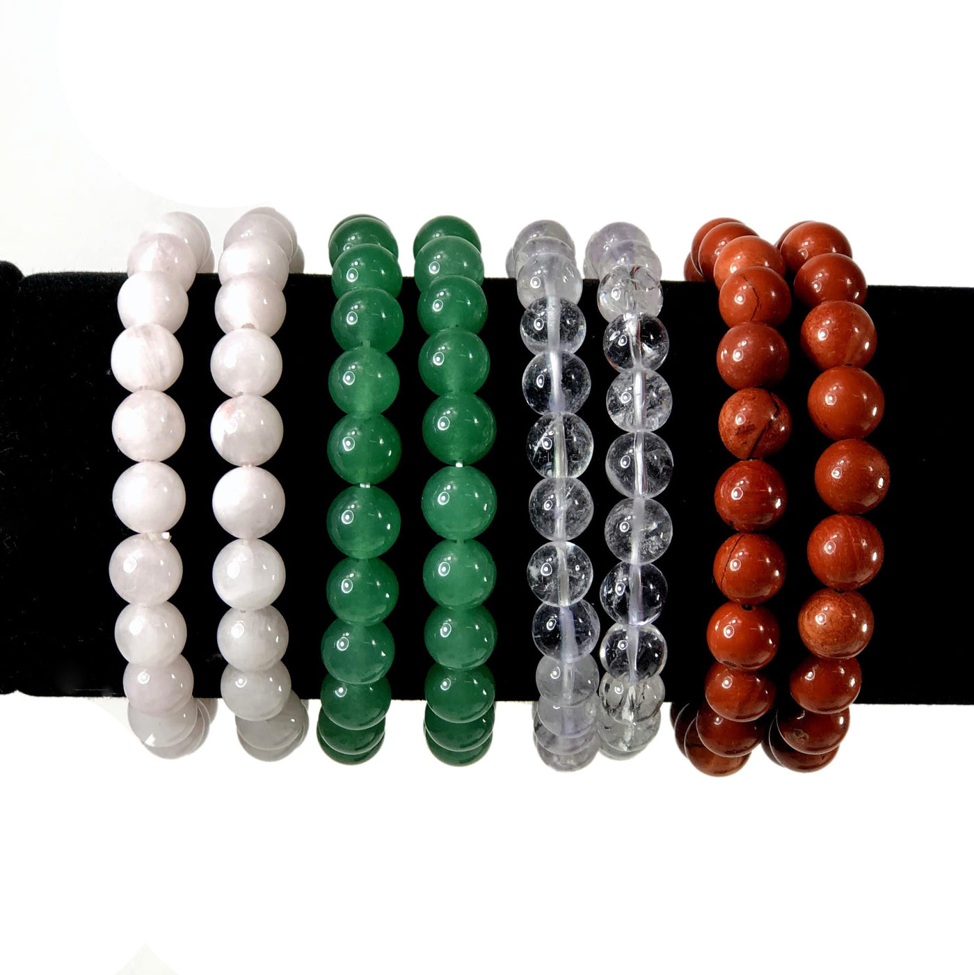 varied healing stone bracelets on a display stand with white background