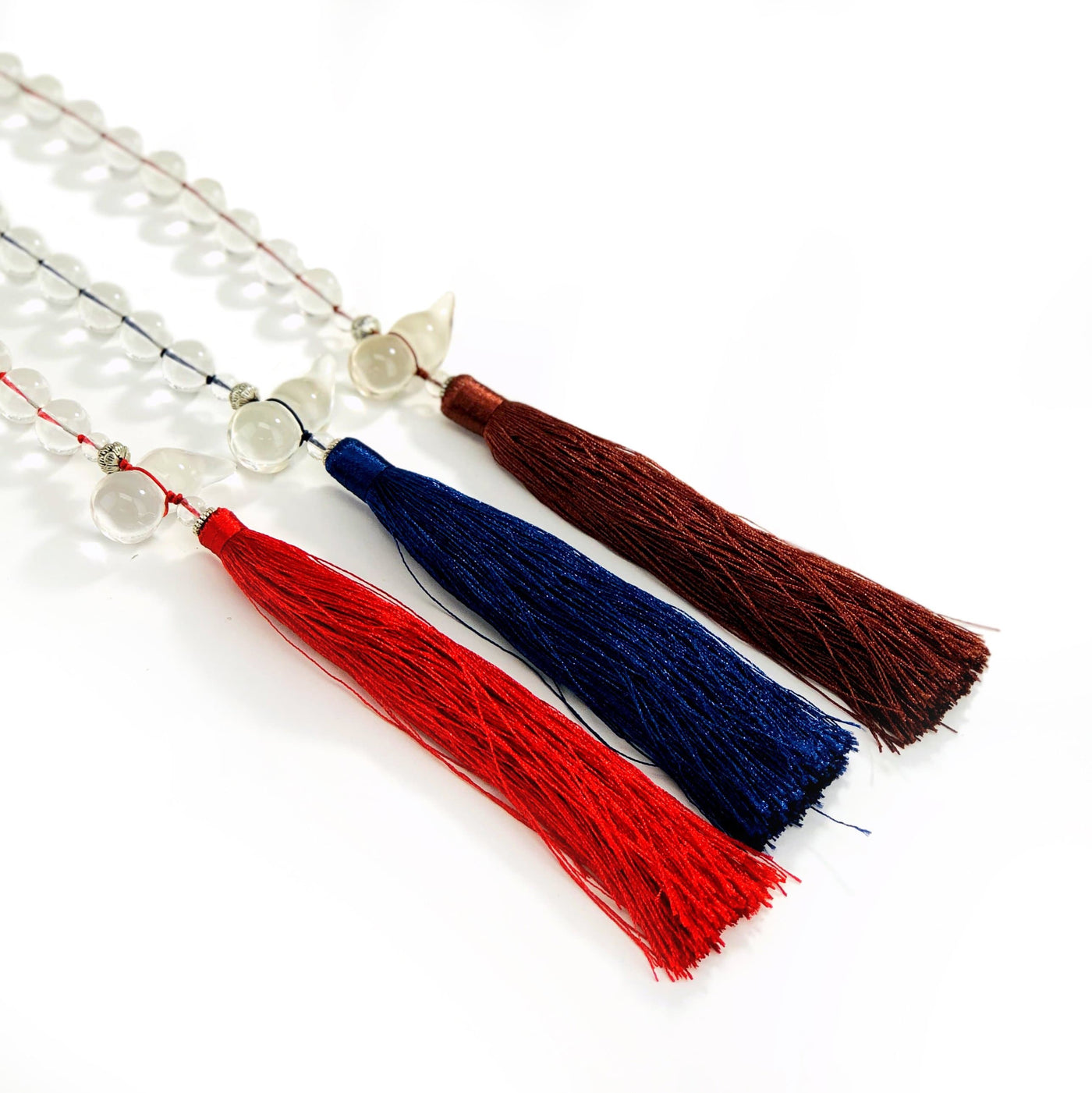 assorted colored tassels with  beads on a table