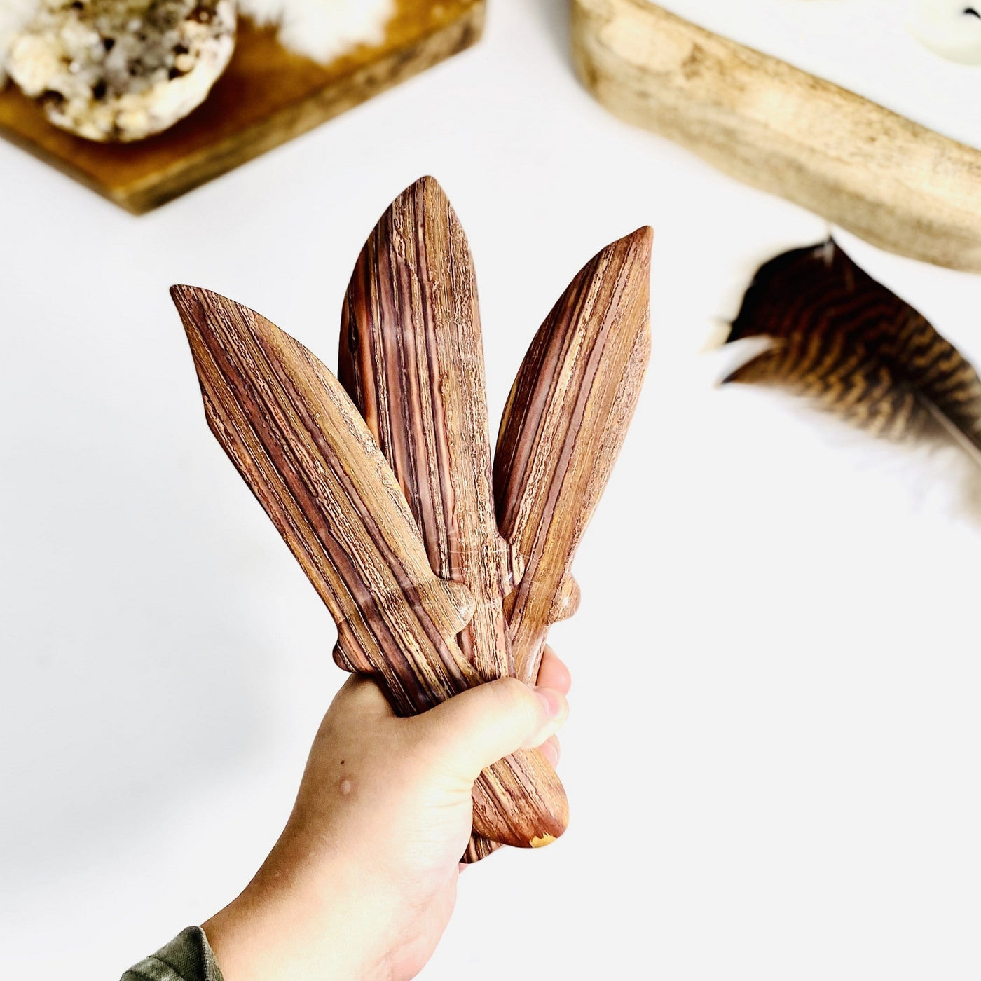 Petrified Wood Knifes held by hand for size comparison