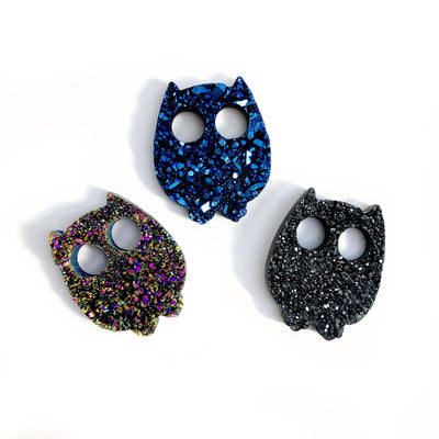 multiple titanium druzy owls displayed to show the differences in the color shades 