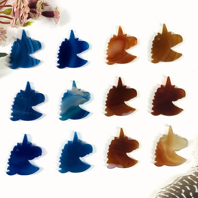Six Blue and natural agate unicorn heads being displayed on a white back ground.