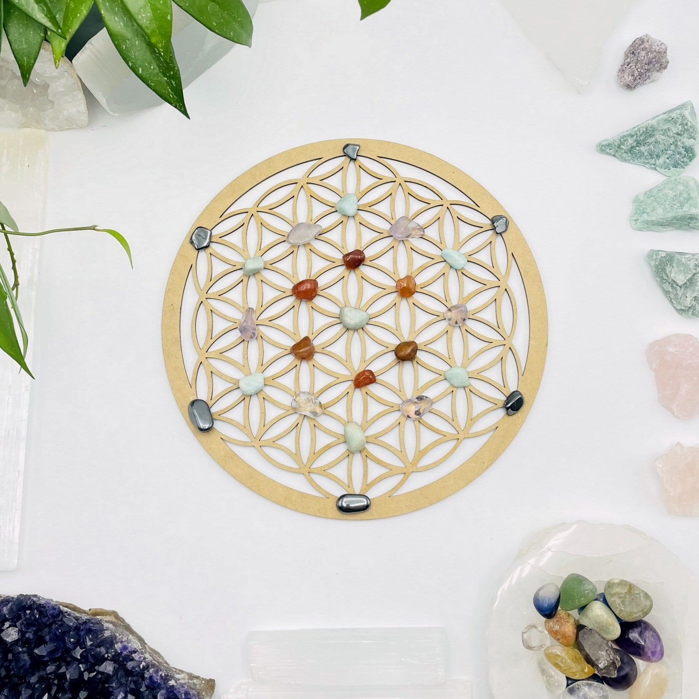 flower of life crystal grid with stones on top of it on white background with decorations