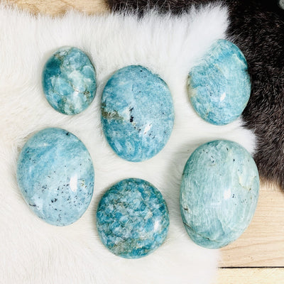 amazonite palm stones are being displayed on a fury surface. 