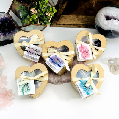 various heart boxes displayed with other crystals in the background