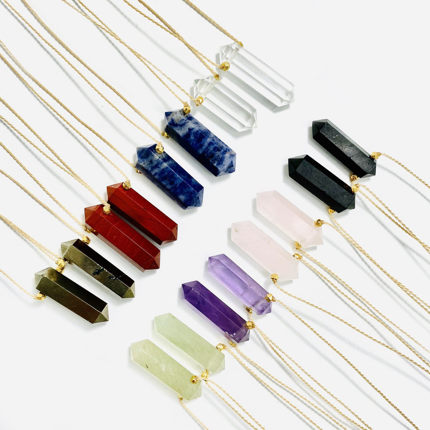 multiple gemstone necklaces displayed to show the differences in the crystals 
