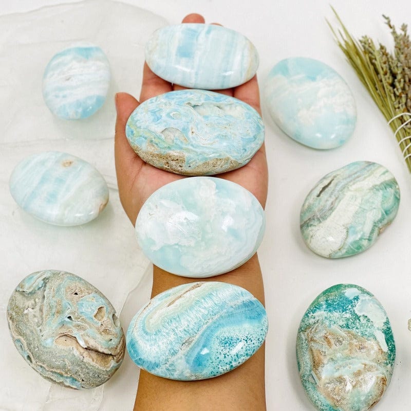 blue aragonite also known as caribbean calcite palm stones in hand