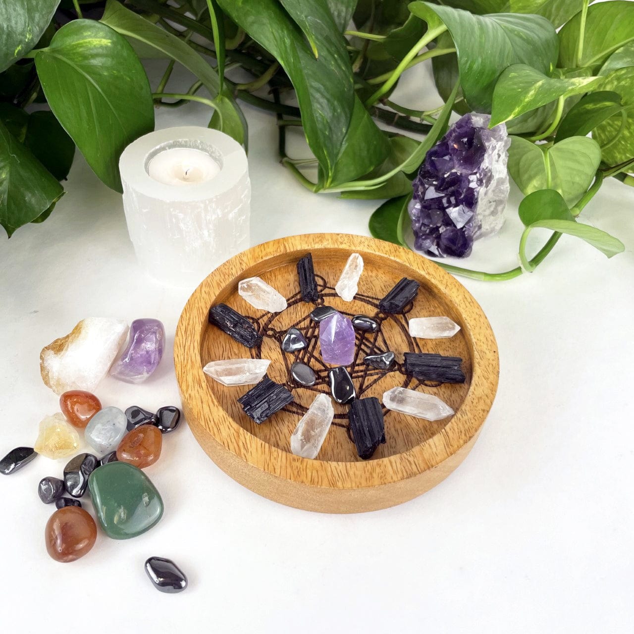 small Metatron Wood Tray in Mango Wood with crystals displayed inside and assorted crystals for decoration next to it on a white background