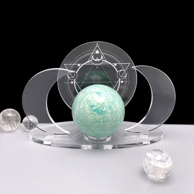 A front facing Acrylic Sphere Holder Crescent Moons - Six Pointed Star holding a sphere with surrounding crystals for display.