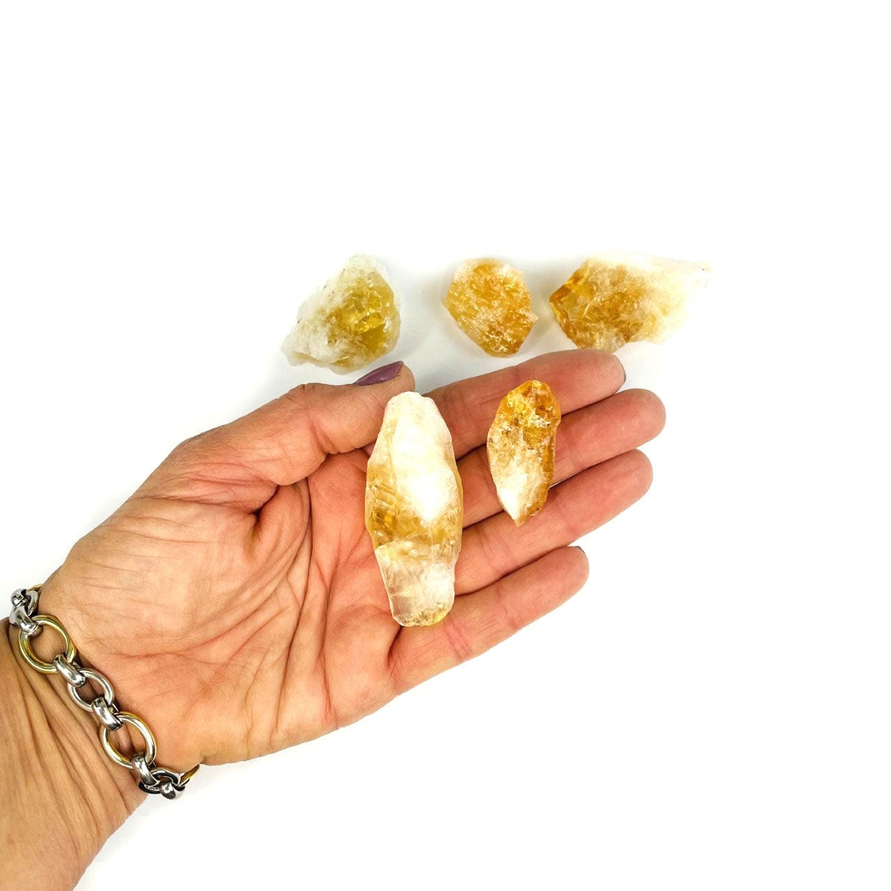 Rough Citrine in a hand showing assorted sizes for size reference