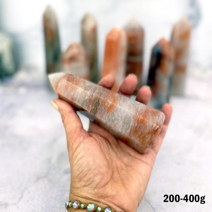 Hematoid Quartz Polished Towers 200-400g displayed in hand for size reference