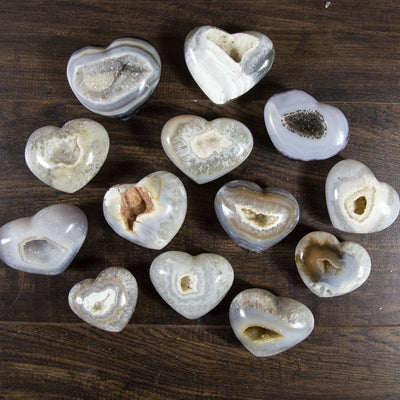 Multiple front facing agate hearts on a dark background.