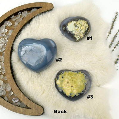 Three numbered Agate Druzy Hearts showing the back side in an alter.